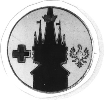 odznaka na agrafkę z wieżą Kościoła Mariackiego w Krakowie, mosiądz 23 mm, emalia niebieska, na niej zarys wieżyw emalii ciemnoniebieskiej