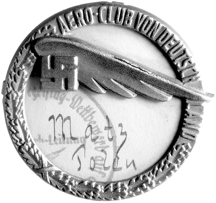 znaczek na agrafkę członka Aeroklubu Niemiec własność pilota Janusza Macińskiego, (patrz opis do medalu nr 860), Koło w kształcie wieńca z liści dębowych i napis AERO-CLUB VON DEUTSCHLAND, na tle koła skrzydło i swastyka, pod nim kawałek papieru z fragmentem pieczęci i odręcznym napisem MATZ POLEN osłonięty płytką plexi, 42.2 mm