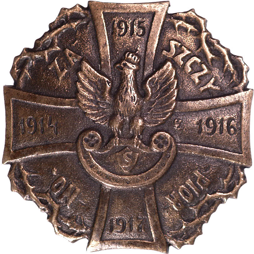 pamiątkowa odznaka żołnierska dla więźniów szeregowców I i III Brygady Legionów internowanych przez władze niemieckie w lipcu 1917 roku w obozie w Szczypiornie. Na równoramiennym krzyżu orzełek strzelecki i daty 1914 / 1915 / 1916 / 1917, krzyż otoczony gałązkami cierniowymi, w tle pomiędzy jego ramionami napis ZA / SZCZY / PIOR / NO., mosiądz, 50 x 50 mm