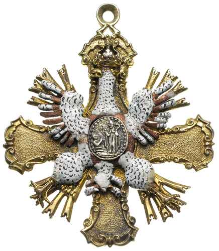 dystynktorium kapituły krakowskiej XVIII wiek, Strona główna: Na równoramiennym krzyżu wykonanym ze srebra złoconego ogniowo umocowany miedziany i emaliowany Orzeł Biały, na piersi Orła owalny medalion przedstawiający biskupa i klęczącą przed nim postać, Strona odwrotna: Pośrodku krzyża emaliowany okrągły, wypukły medalion z trzema koronami, 30.93 g, 67 x 58 mm, uszkodzona emalia, łapa i ogon orła