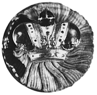 odznaka w kształcie korony, złoto emalia biała, czerwona i niebieska, na okrągłej podkładce srebrnej obciągniętejmateriałem, z nakrętką. Jest to odznaka noszona przez członka Kapituły Orderu Św. Stanisława odznaczonegojednocześnie orderem I klasy, nieznaczne ubytki emalii i utrącony krzyżyk na jabłku